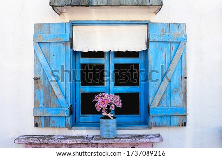 Blue wooden vintage window on the white wall.