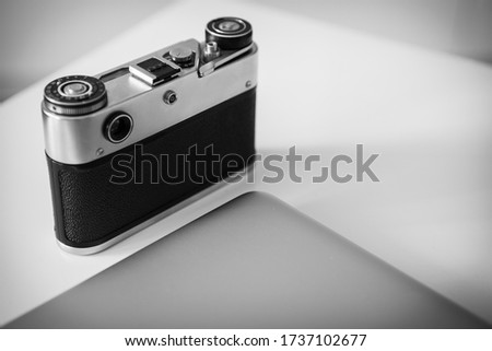 Modern laptop and vintage camera