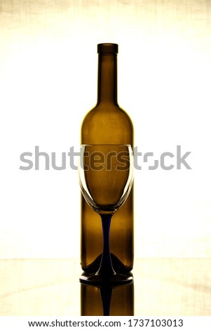 A bottle of wine and a glass glass