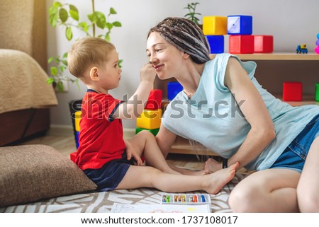 A young mother and child spend time together. They have fun, draw and play. Concept of a happy time with your family at home.