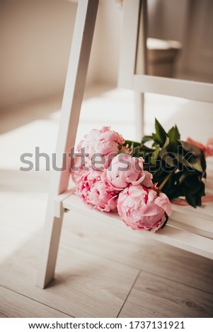 open flower buds, pink peonies flowers lie on a wooden stand mirror