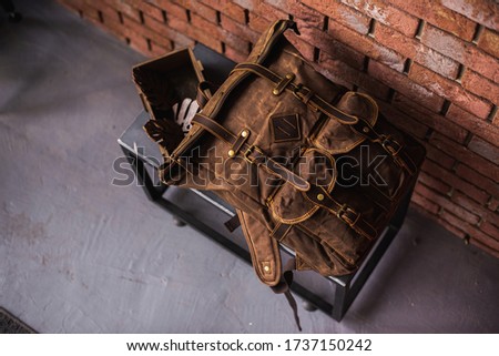 vintage canvas backpack near brick wall