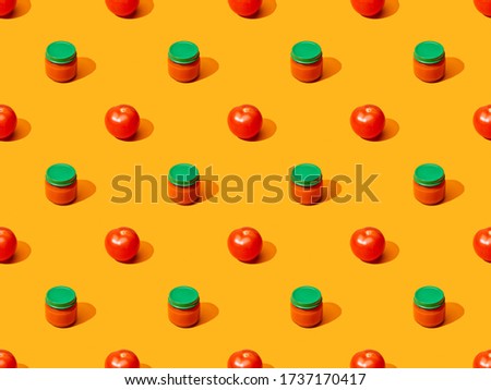 fresh tomatoes and puree in glass jars on orange colorful background, seamless pattern
