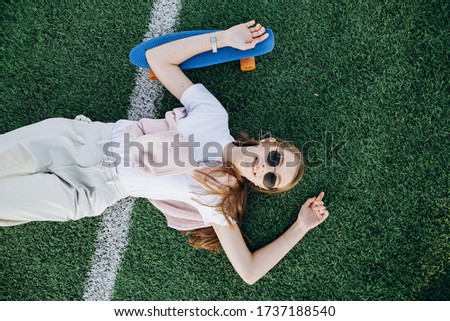 sports girl girl lying on the grass soccer field girl and skateboard summer photo shoot girl with glasses sports model
