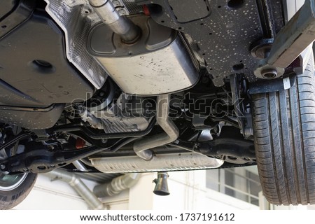 Car on a lift in a car service. View of the car from below. Royalty-Free Stock Photo #1737191612