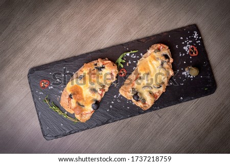 Two brutal sketches with cheese, olives, mushrooms on stone plates. restaurant giving. for the menu of cafe. wooden table