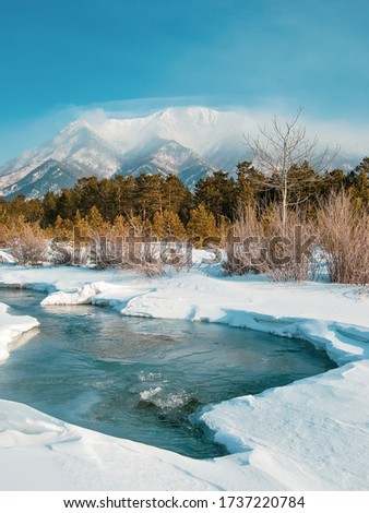 colorful view of the snow-white mountain and the river, wild life, Winter stream, winter background, travel photo Royalty-Free Stock Photo #1737220784