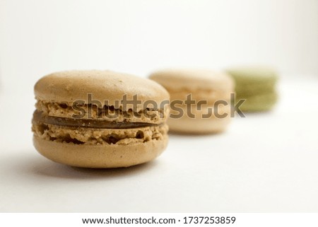 A row of three macarons receeding into the background with selective focus on foreground