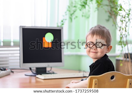 A little boy wearing glasses and an eye patch (plaster, occluder). Computer "game" software vision treatment to prevent amblyopia and strabismus (squint, lazy eye). Child congenital vision disease. Royalty-Free Stock Photo #1737259508