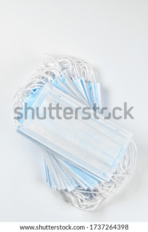 medicine, healthcare and pharmacy concept - many blue disposable medical masks on a white background. Copyspace. Flatlay