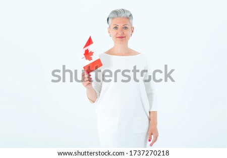 Middle aged woman with Canada flag in white background.