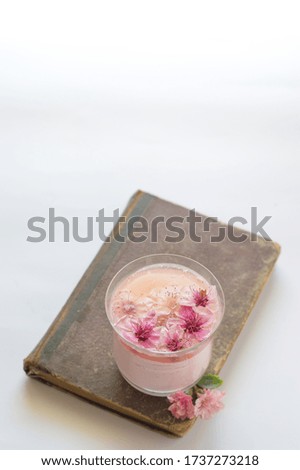 Pink mousse with peach flowr on top. White background. 