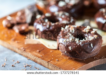 Chocolate donuts with chocolate glaze, nuts. National Donut Day. Homemade baking. Selective focus, copy space