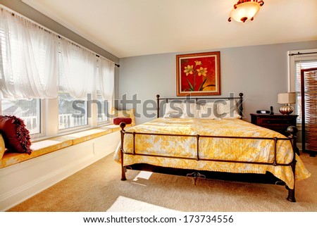 Gentle cozy bedroom with bright white window, yellow bed and beautiful picture on the wall