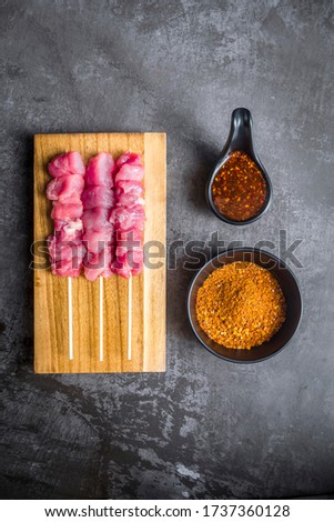 Raw Beef/Pork meat sticks seasoning with Sichuan pepper powder on top prepared for roasting. Image using for commercial or menu layout design 