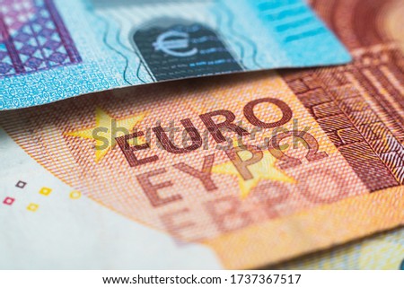 Macro photograph of the word euro on a euro banknote. European monetary system. The ECB prints money and buys bonds. Danger of inflation