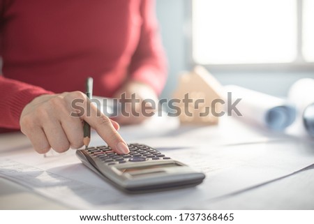 Architect working on blueprint. Architects workplace - architectural project, blueprints, ruler, calculator, laptop and divider compass. Construction concept. Blue print is fake only for stock photo.