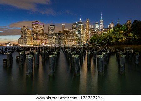 Beautiful Night Light and Lower Manhattan skyline with East River and New York City. Twilight with Reflections and Abandoned Pier at Sunset from Brooklyn Bridge Park