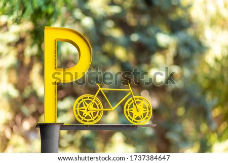Designation of parking for bicycles. Big yellow letter P on a pillar.