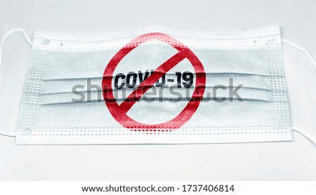 surgical mask with the prohibition red sign to Coronavius covid-19 printed. Pandemic covid-19 and preventive measures to counter the spread of the virus