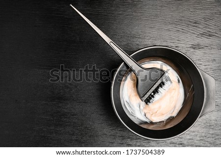 Tools for hair dyeing on the black wooden background. Colouring of hair at home Royalty-Free Stock Photo #1737504389