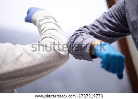 Business colleagues greeting with elbows during coronavirus pandemic. stock photo