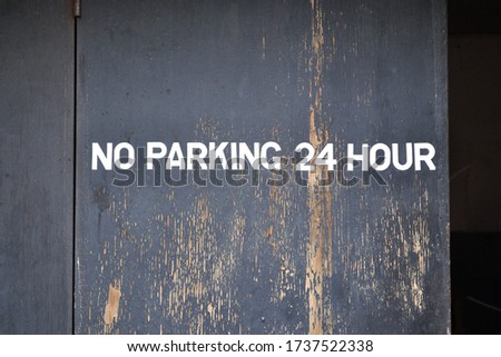 No Parking Sign on Old Wooden Door 