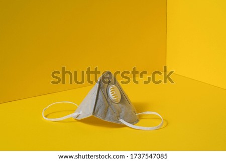 studio session of gray face protection masks, on yellow background