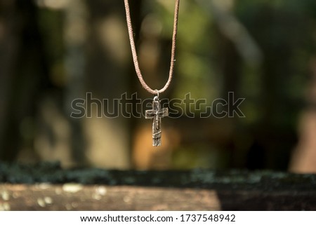 A silver metal old crucifix of Jesus Christ on a cross, hanging as a rosary on Holy Grabarka Mountain - the main Orthodox pilgrimage site in Poland