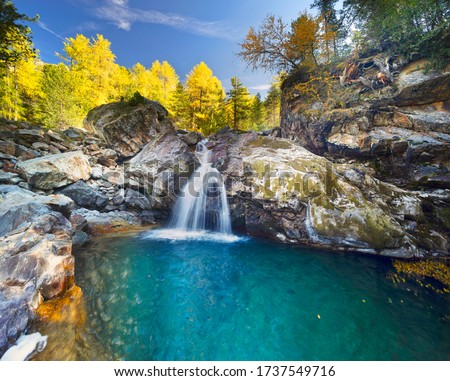 
Waterfall in the Alps in the province of Morteratsch, near the famous railway. Autumn trees over the stormy water of a mountain river. Royalty-Free Stock Photo #1737549716