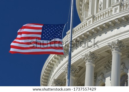 U.S. Capitol Dome  and waving US National flag close-up - Washington D.C. United States of America Royalty-Free Stock Photo #1737557429