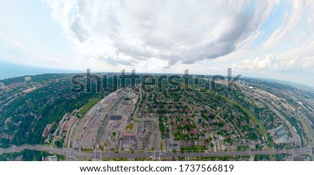 Artistic view of Toronto city at cloudy sky day. Panoramic summer landscape in  Ontario, Canada. North American urban commuter background of houses, stores, parking, and roads with green trees. 