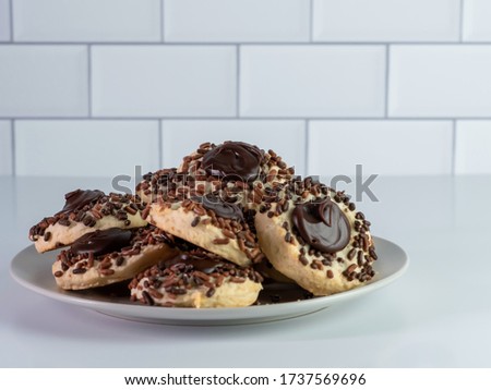 A closeup picture of delicious chocolate stuffed cookies in a white plate against a grey background