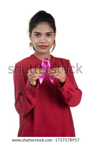 Healthcare and medicine concept - young woman hands holding pink breast cancer awareness ribbon