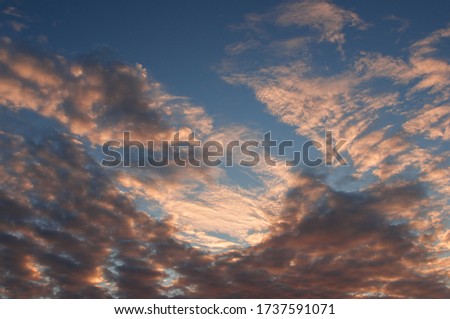 Blue sky and and golden sunset clouds background. Beautiful summer sky with golden sunset clouds