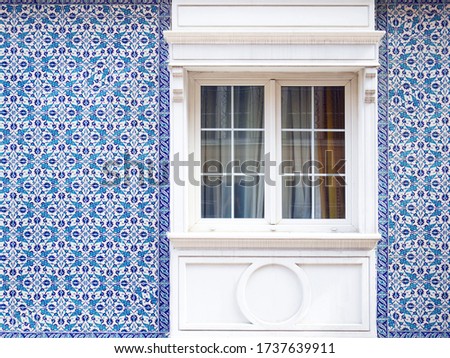 Window in a turkish facade. Blue floral arabic ceramic tiles.