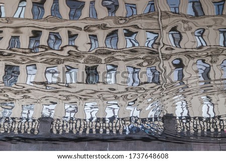 Facade of grey vintage building reflected in chanel 