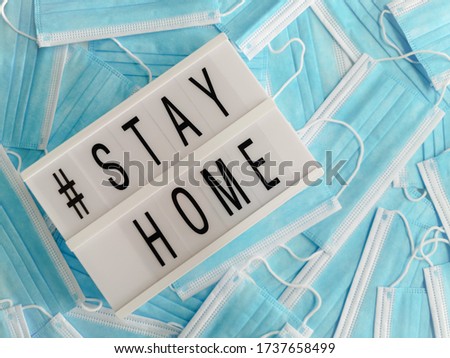 Blue surgical face masks with a white light box stating # Stay Home
