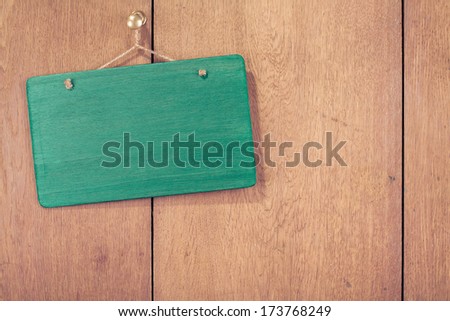 Wooden signboard with rope hanging on planks wall background