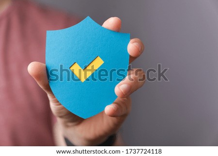 A sign of the checkmark made of paper in the hands of a man