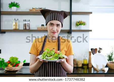 Asian women present fresh food. Housewife trying to cooking and showing vegetables Salad in kitchen in house to take picture for sell food box online. Work from home / Stay at home / covid19 concept