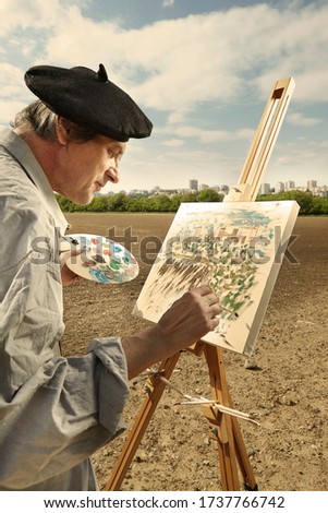 Older man painting artwork on canvas in sunny day field