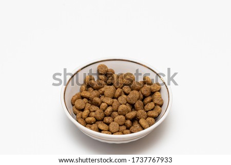 Balls of cat food in a beautiful bowl on a white background, isolate. The concept of pet food.
