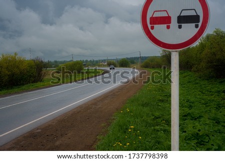 A car going off into the distance on a turn on the road in the rain