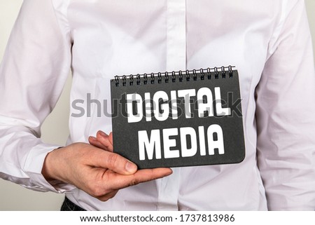 DIGITAL MEDIA concept. Woman holding black notebook with text