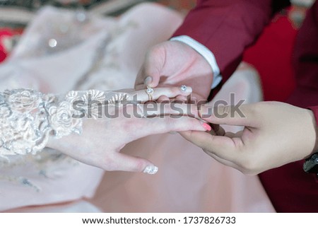 The image of wearing a wedding ceremony ring