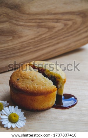 Close up picture of homemade muffin broken on two parts and from inside following chocolate glaze on wooden background with copy space flat lay concept of food photography on wallpaper 