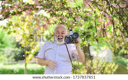 Senior man holding professional camera. Photography courses. Become photographer. Education for elderly. Grandfather hobby. Images that tell story. Power behind picture. Vintage camera. Retro camera.