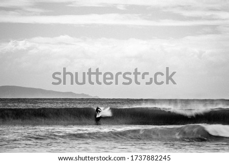 Surfer riding a beautiful wave of the Mediterranean Sea that is unleashed. Ajaccio, France - May 5, 2019.