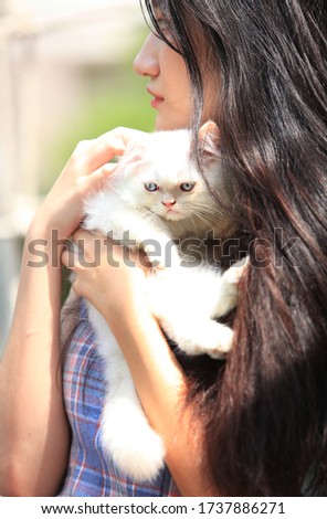 Beautiful young woman with cute white Persian cat resting at home